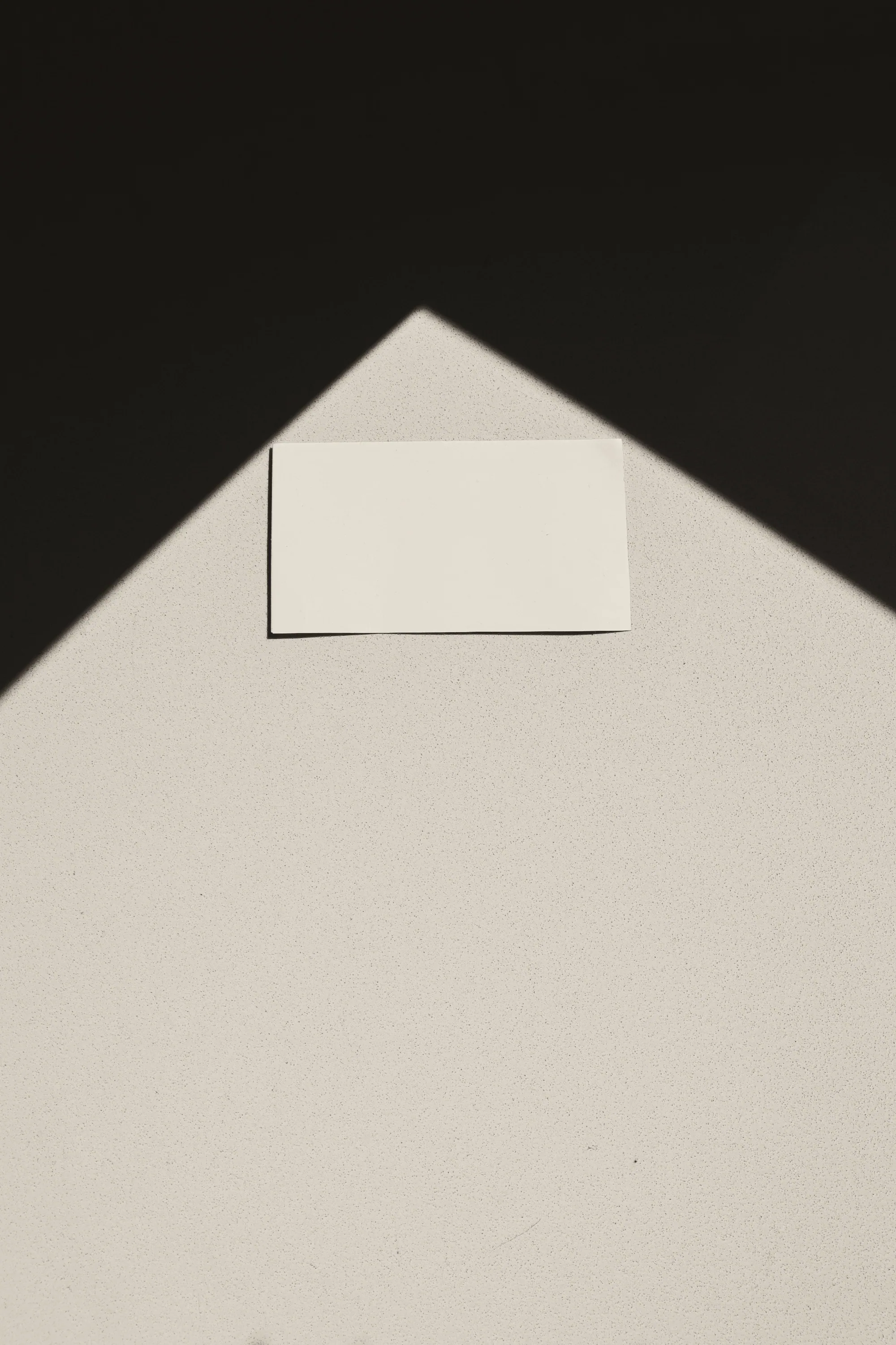 Blank card resting in an angular shadow